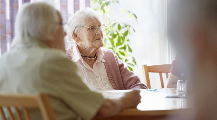 Äldre kvinna (100 år) i uppehållsrum på äldreboende.