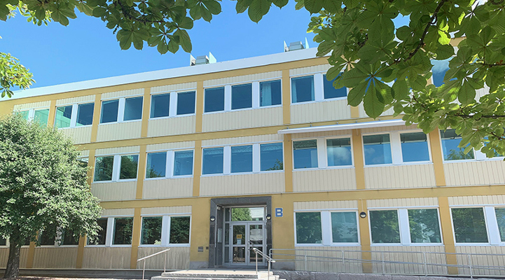 Bild på gul tegel byggnad med många fönster