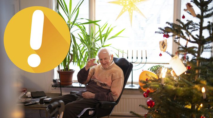 Äldre man sitter i en fåtölj bredvid en julgran. En gul ring med ett vitt utropstecken.