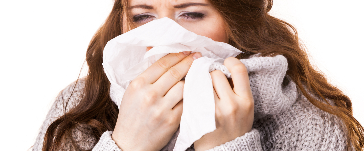 Sick freezing woman sneezing in tissue. Girl wearing warm sweater being cold and trembling. Flu or other virus. Health care.
