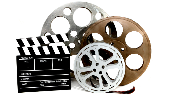 Film Canisters With Directors Clapboard on White Background