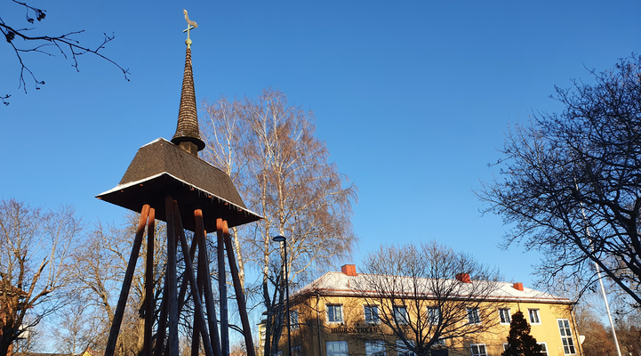Klockstapeln i Vilhelminaparken. I bakgrunden Brukskyrkan i gult
