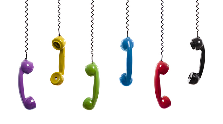 Sex färgglada telefonlurar hänger uppifrån i sina sladdar.